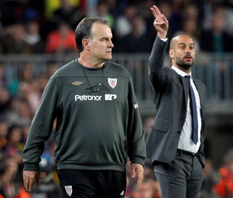 FILE PHOTO: Barcelona's coach Pep Guardiola and Athletic Bilbao's coach Marcelo Bielsa react during their Spanish First division soccer league match at Camp Nou stadium in Barcelona