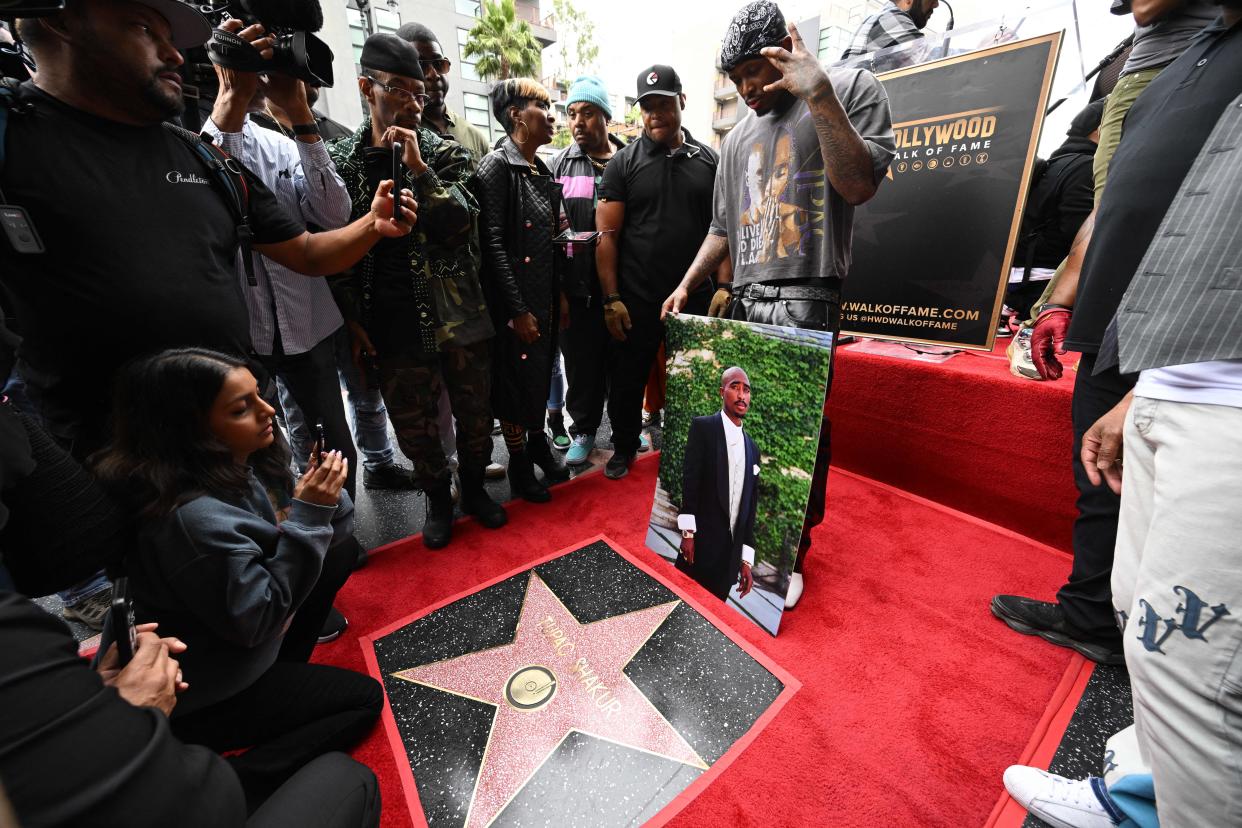 Rapper YG holds a portrait of Tupac during Tupac Shakur's Hollywood Walk of Fame star ceremony in June.