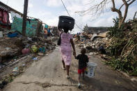 <p>A woman walks to a shelter with her son as they leave after their home was destroyed by Hurricane Matthew in Jeremie, Haiti on Sunday, Oct. 9, 2016. (AP Photo/Dieu Nalio Chery)</p>