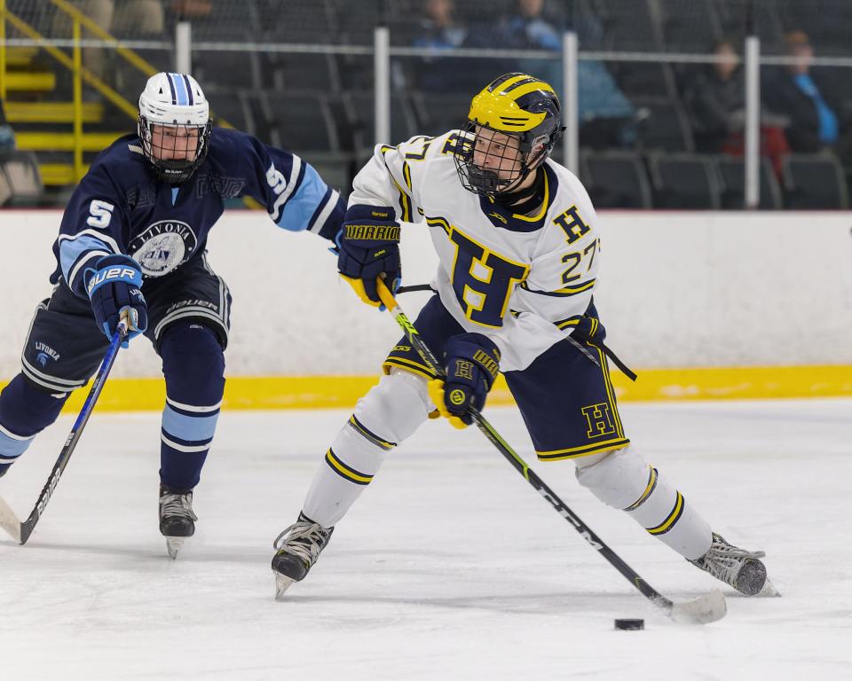 Hartland's Drew L'Esperance (27) fires a shot while Livonia Stevenson's Logan Barnes closes in during the Eagles' 4-3 victory Wednesday, Jan. 18, 2023.