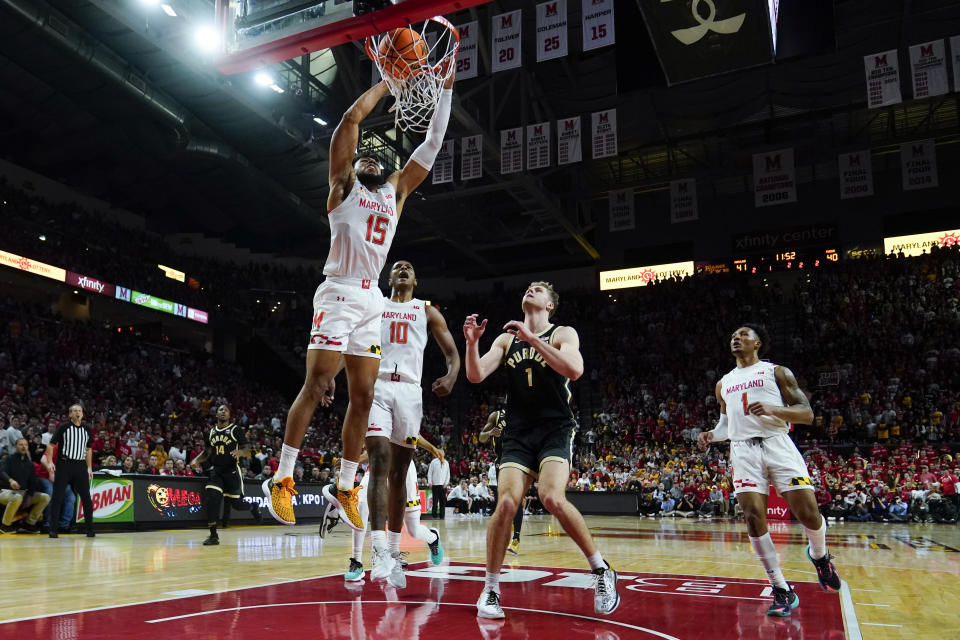 Maryland forward Patrick Emilien (15) uses two hands to dunk on Purdue forward Caleb Furst, center, during the second half of an NCAA college basketball game, Thursday, Feb. 16, 2023, in College Park, Md. Maryland won 68-54. (AP Photo/Julio Cortez)