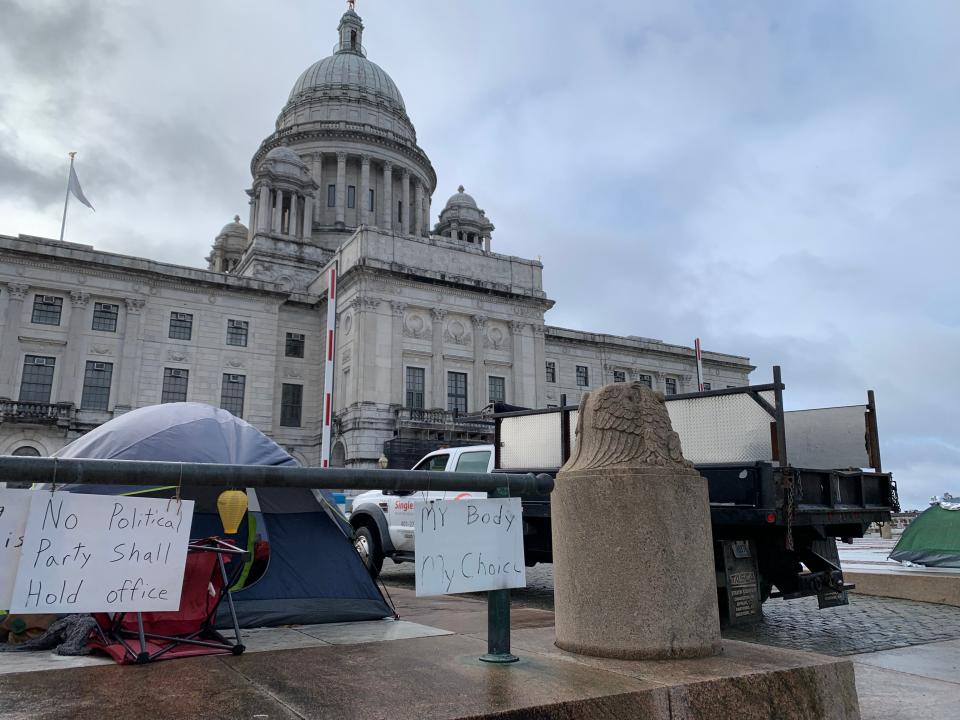 Signs left by homeless people who had been camped out for months in front of the State House were still on display Saturday morning as contractors cleared their tents and other belongings.