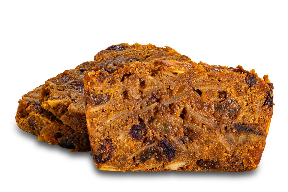 Closeup view of sliced delicious homemade fruitcake isolated on white background with clipping path.