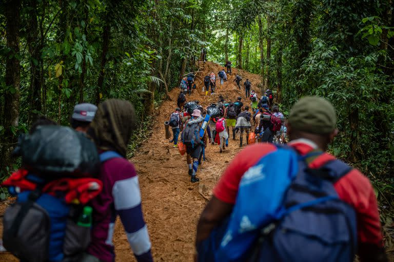 Los migrantes, cargados con sus pertenencias que se vieron obligados a dejar caer a medida que la caminata se hacía más difícil, cruzan el Tapón del Darién. (Federico Rios/The New York Times)