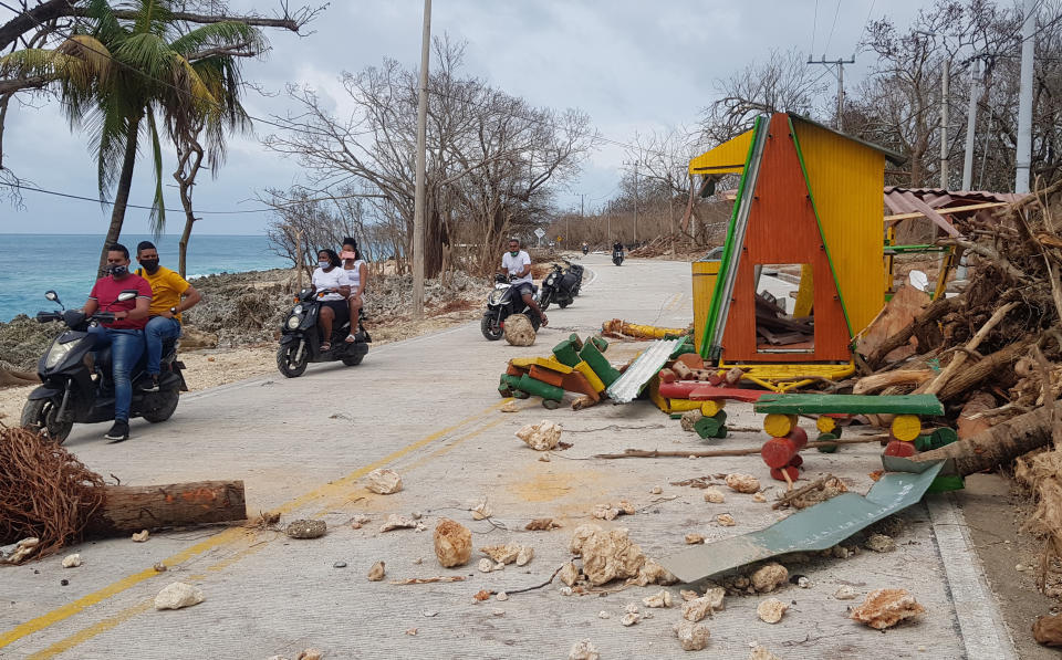 Motorcyclists pass debris on the road after the passing of Hurricane Iota on San Andres Island, Colombia, Tuesday, Nov. 17, 2020. Iota moved over the Colombian archipelago of San Andres, Providencia and Santa Catalina, off Nicaragua’s coast, as a Category 5 hurricane. (AP Photo/Christian Quimbay)