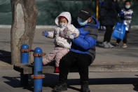 A man lifts a child at a park in Beijing, China, Thursday, Jan. 13, 2022. The number of babies born in China continued to shrink last year in a decade-long trend, official data showed Monday, Jan. 17, as a declining workforce adds pressure to the ruling Communist Party's ambitions to boost national wealth and global influence. (AP Photo/Ng Han Guan)