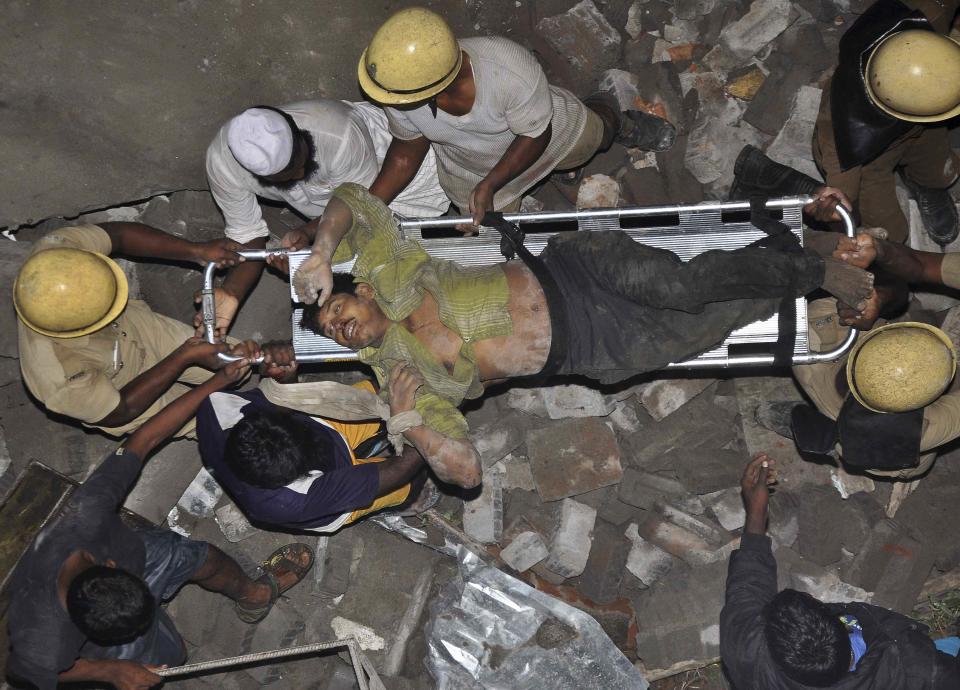 Rescue workers carry an injured man at the site of a collapsed 11-storey building that was under construction on the outskirts of the southern Indian city of Chennai