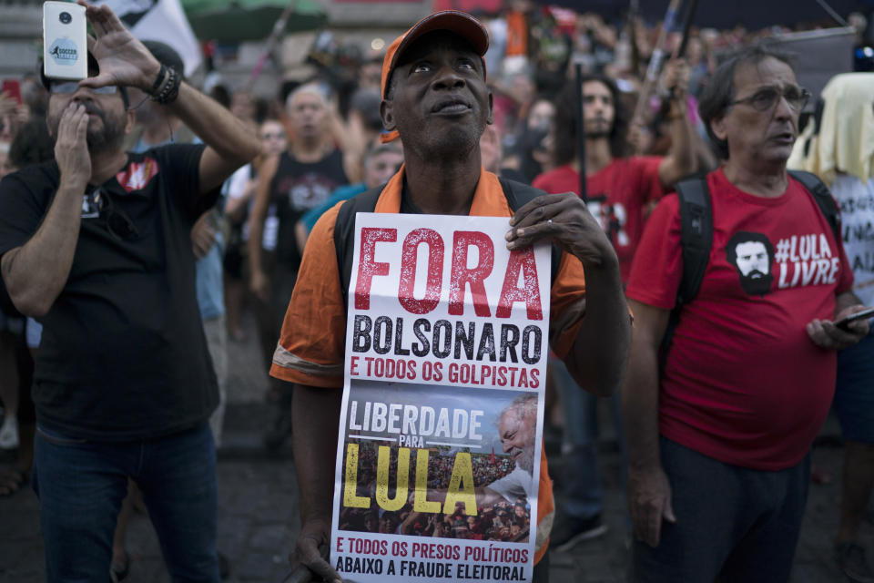 A man holds a sign that reads in Portuguese "Bolsonaro and all the putschists out. Freedom to Lula," during a protest against the military coup of 1964 in Rio de Janeiro, Brazil, Sunday, March 31, 2019. Brazil's president Jair Bolsonaro, a former army captain who waxes nostalgic for the 1964-1985 dictatorship, asked Brazil's Defense Ministry to organize "due commemorations" on March 31, the day historians say marks the coup that began the dictatorship. (AP Photo/Leo Correa)