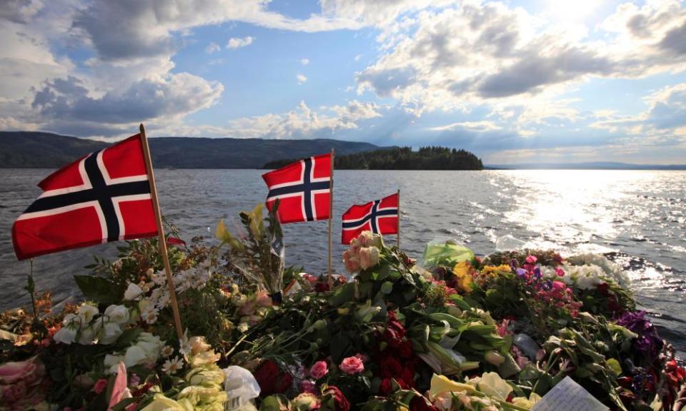 Norwegian flags and flowers are seen close to Utøya island.