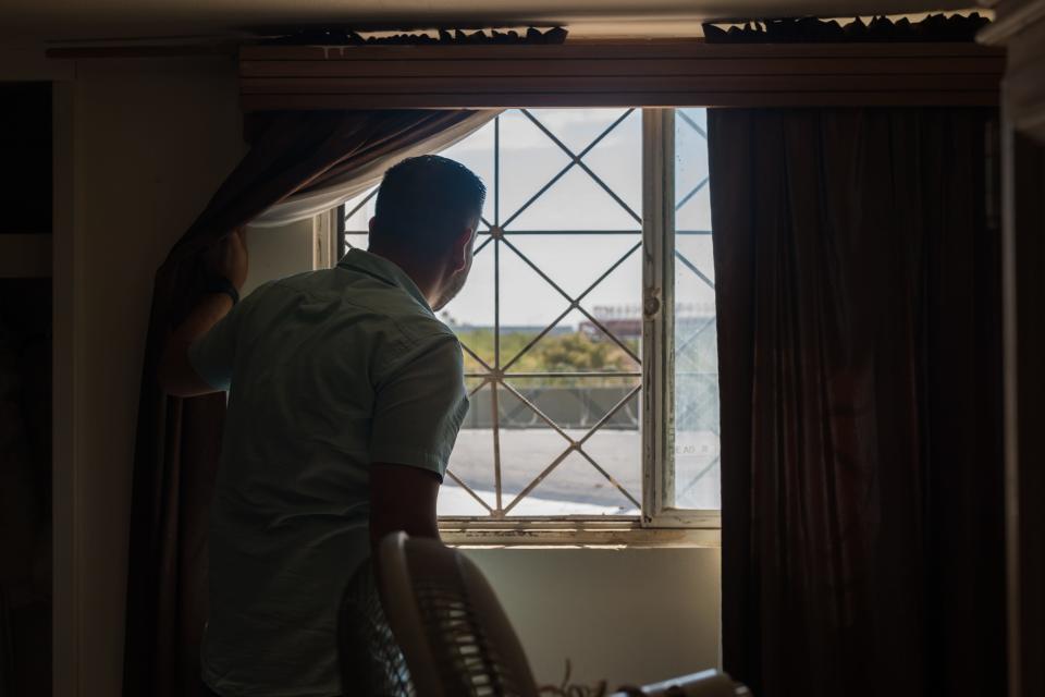 Gabe Vasquez, a candidate for New Mexico's southernmost congressional seat, looks at the train tracks he used to play at through a window in a room at his grandparents' house in Juárez on Saturday, July 9, 2022.