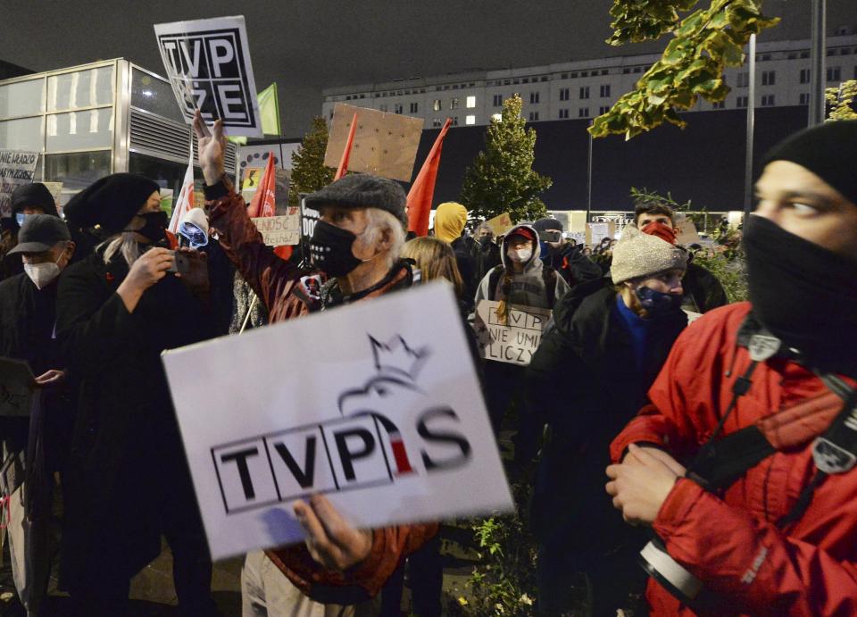 Protesters gathered before Poland's state TVP building with angry chants against the government on the eighth straight day of demonstrations against a court ruling that further tightened the predominantly Catholic nation's restrictive abortion law in Warsaw, Poland, Thursday, Oct. 29, 2020. A massive protest is planned for Friday, despite calls by the prime minister for no gatherings at the time of a steep spike in new COVID-19 infection cases.(AP Photo/Czarek Sokolowski)