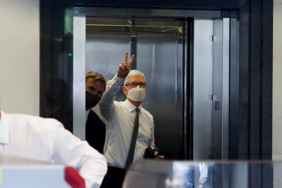 Apple CEO Tim Cook gestures from the elevator as he arrives to speak during a weeks-long antitrust trial at federal court in Oakland, California, U.S. May 21, 2021.  REUTERS/Brittany Hosea-Small