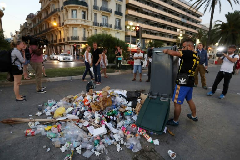 A man empties a rubbish bin on July 18, 2016 on the Promenade des Anglais seafront in Nice, the site where a Tunisian drove a truck into a crowd killing 84