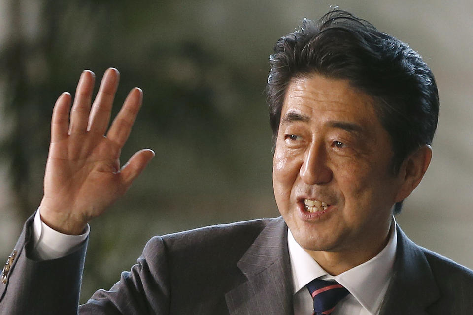 FILE - Japan's newly-named Prime Minsiter Shinzo Abe waves at the media upon his arrival at the prime minister's official residence following his election at Parliament in Tokyo on Dec. 26, 2012. In 2012, after again being elected Liberal Democratic Party president, Abe became prime minister for the second time. (AP Photo/Shizuo Kambayashi, File)