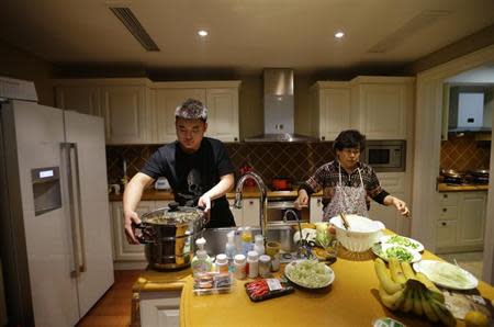 Bodyguard Han, who was hired from Tianjiao Special Guard/Security Consultant, helps his employers to prepare dinner on the outskirts of Beijing December 12, 2013. REUTERS/Jason Lee