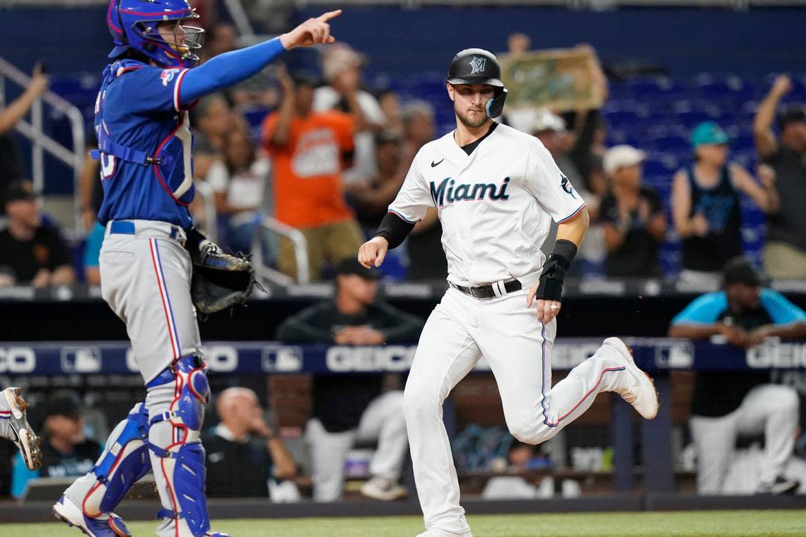 Miami Marlins’ Charles Leblanc, right, scores past Texas Rangers catcher Jonah Heim, left, on a single hit by Jon Berti in the fifth inning during Game 2 of a doubleheader baseball game, Monday, Sept. 12, 2022, in Miami. 