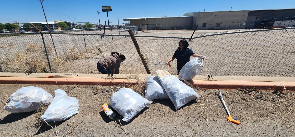 Volunteers with Keep Amarillo Clean clean up area outside the closed United Artists movie theatre Monday near Amarillo Boulevard in West Amarillo.