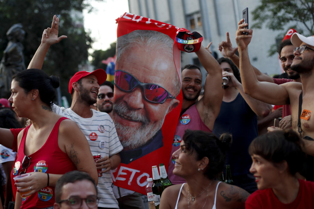Supporters of Brazil's former President Luiz Inacio Lula da Silva, who is running for president again, celebrate partial results after polls closed in the country's presidential run-off election, in Rio de Janeiro, Brazil, Sunday, Oct. 30, 2022. (AP Photo/Bruna Prado)