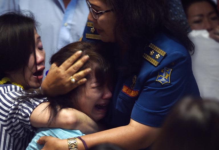 Family members of passengers onboard AirAsia flight QZ8501 react after watching news reports showing an unidentified body floating in the Java sea, inside the crisis-centre set up at Juanda International Airport in Surabaya