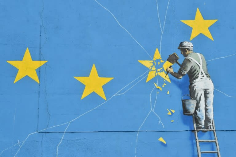 A mural by British artist Banksy depicting a workman chipping away at one of the stars on a European Union themed flag
