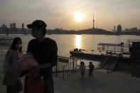 Residents walk along the Yangtze River on a ferry in Wuhan in central China's Hubei province on Wednesday, April 8, 2020. Streets in the city of 11 million people were clogged with traffic and long lines formed at the airport, train and bus stations as thousands streamed out of the city to return to homes and jobs elsewhere. Yellow barriers that had blocked off some streets were gone, although the gates to residential compounds remained guarded. (AP Photo/Ng Han Guan)