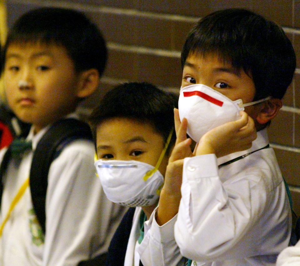 Primary school students wear masks to protect themselves from getting the killer pneumonia virus in Hong Kong March 24, 2003.