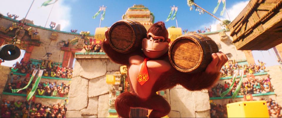Donkey Kong holding up two wooden barrels in the Kong Island Arena of The Super Mario Bros. Movie