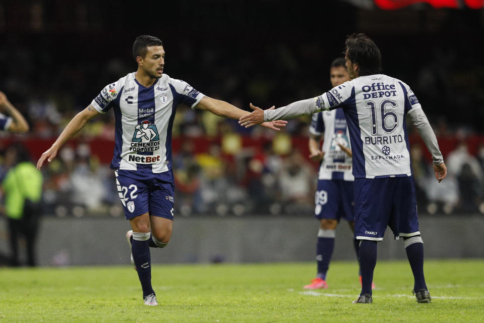 Gustavo Cabral, izquierda, de los Tuzos de Pachuca, es felicitado por su compañero Jorge Hernández después de anotar el segundo gol de su club ante el América en el juego de vuelta de los cuartos de final del torneo Clausura mexicano, en el estadio Azteca de Ciudad de México, el domingo 16 de mayo de 2021. (AP Foto/Eduardo Verdugo)