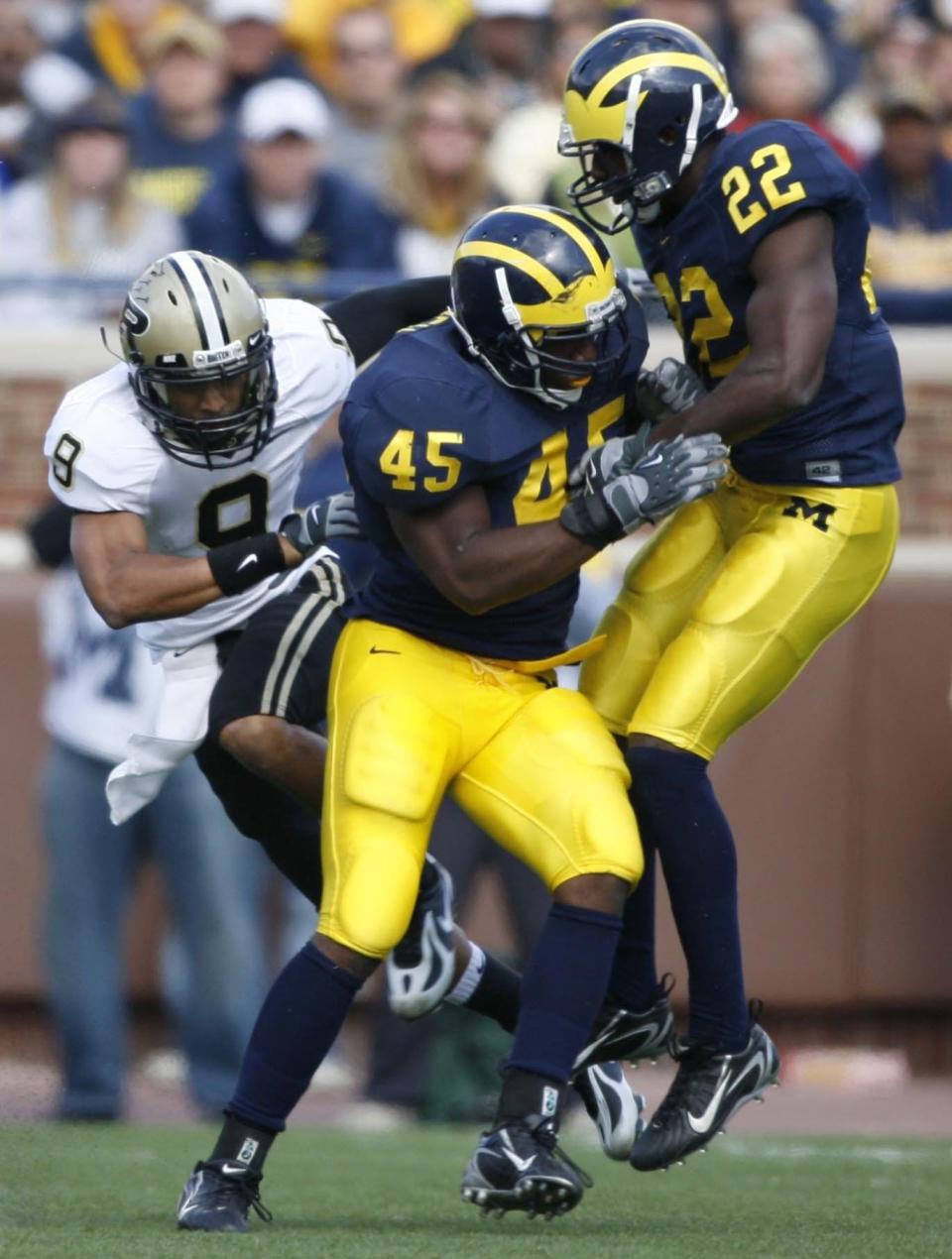 Michigan's Obi Ezeh (45) and Doug Rogan (22) separated Purdue's Keith Smith from a would-be reception that ended up in the hands of Michigan's Brandon Harrison for an interception late in the first half in Ann Arbor on Saturday, Oct. 13, 2007.