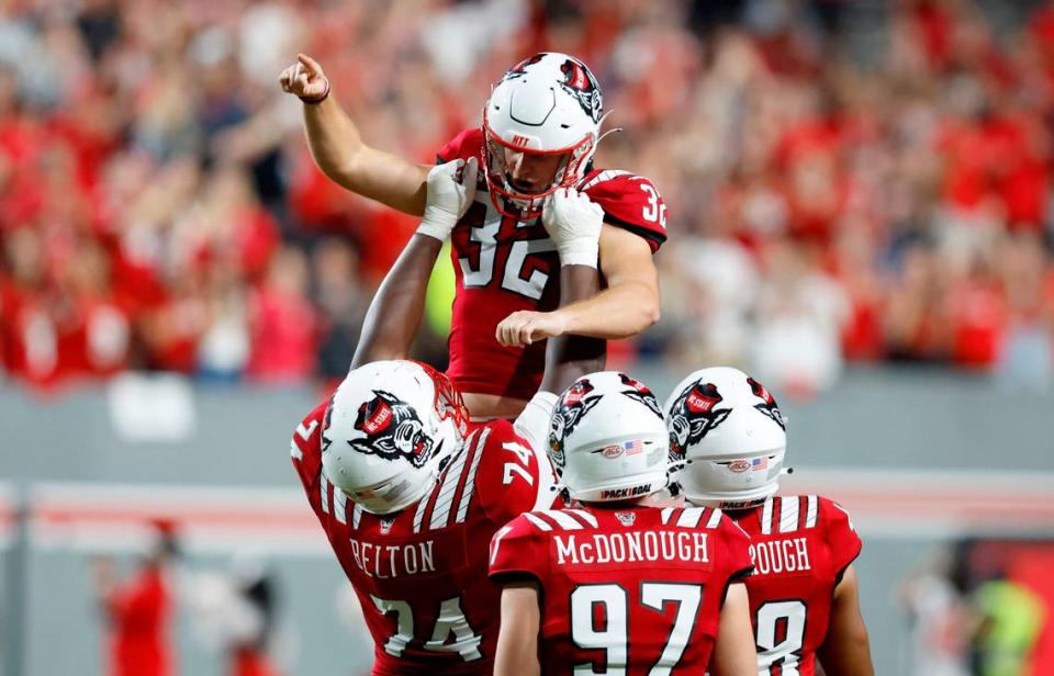 N.C. State’s Christopher Dunn (32) is hoisted by Anthony Belton (74) after he kicked a field goal during Boston College’s 21-20 victory over N.C. State at Carter-Finley Stadium in Raleigh, N.C., Saturday, Nov. 12, 2022. The field goal set a new ACC career field goal record.