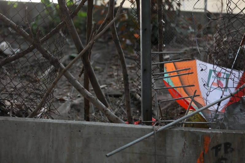 A damaged fence and an umbrella are seen outside the Hong Kong Polytechnic University (PolyU) in Hong Kong