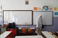 A worker in protective suit disinfects a classroom of an elementary school, as a measure against the spread of the coronavirus disease (COVID-19), in the city of Ioannina
