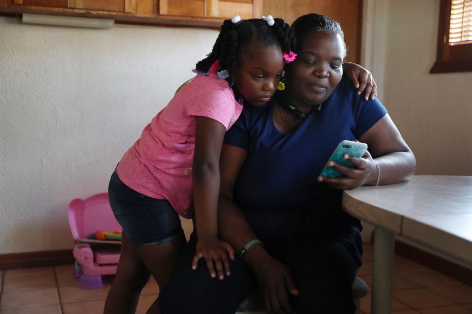 Willie Mae Daniels watches videos with her granddaughter, Karyah Davis, 6, after being laid off from her job as a food service cashier at the University of Miami on March 17 as the university tries to fight coronavirus.