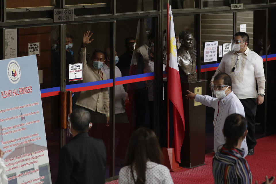 Lawmakers supporting new house speaker Lord Allan Velasco waves after finding another way to enter the plenary hall which has the main entrance locked earlier at the House of Representatives in Quezon city, Philippines, Tuesday, Oct. 13, 2020. A large faction of Philippine legislators in the House of Representatives elected a new leader Monday in a tense political standoff between two allies of the president. (AP Photo/Aaron Favila)