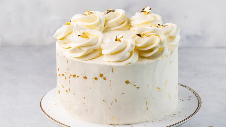 white cake with decorative icing on a cake stand