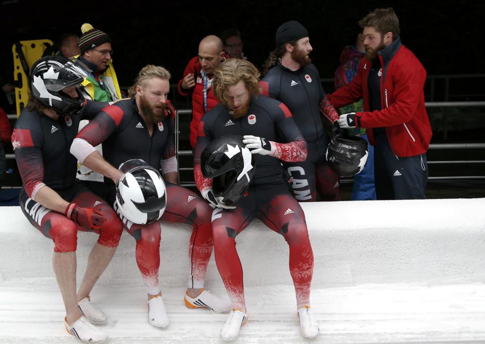 Canada's pilot Justin Kripps (C) sits with teammates after a crash in the four-man bobsleigh event at the Sochi 2014 Winter Olympics, at the Sanki Sliding Center in Rosa Khutor February 22, 2014. REUTERS/Murad Sezer (RUSSIA - Tags: SPORT BOBSLEIGH OLYMPICS)