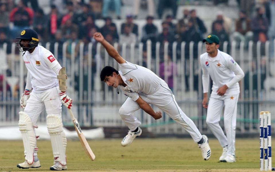 Pakistan's Naseem Shah (C) delivers a ball next to Sri Lanka's Dilruwan Perera (L) as Pakistan's Shaheen Shah Afridi (R) looks on during the third day of the first Test cricket match between Pakistan and Sri Lanka at the Rawalpindi Cricket Stadium - AAMIR QURESHI / AFP