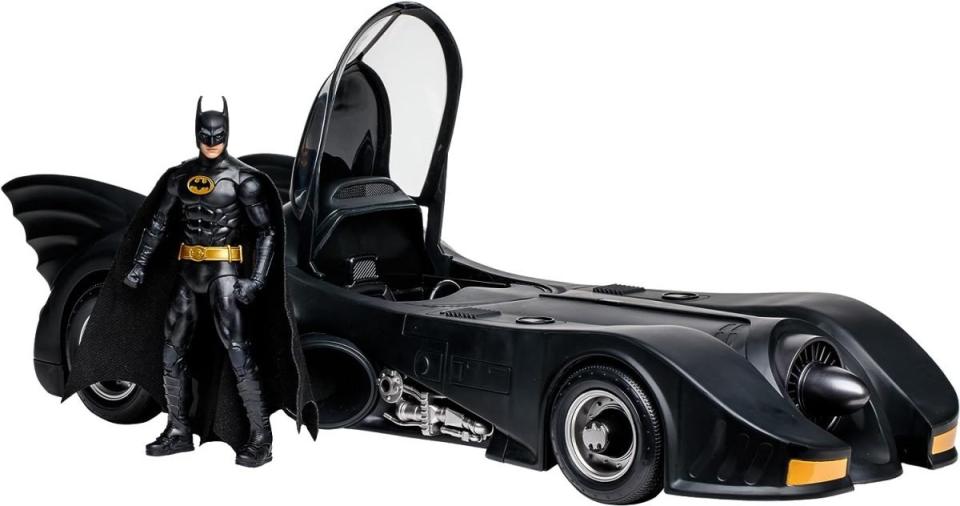 A replica 1989 Batmobile and Batman figure standing next to it from McFarlane