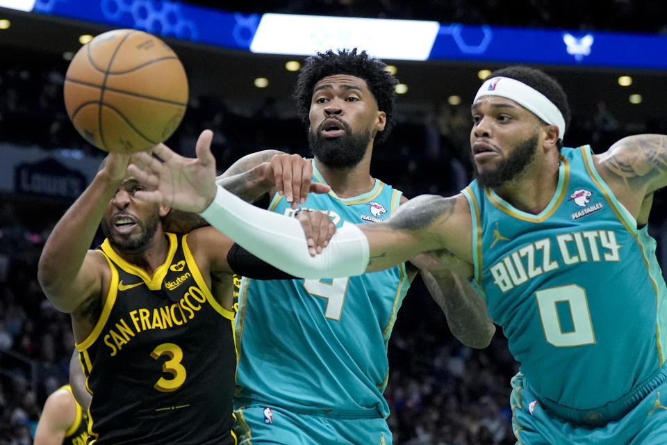 Golden State Warriors guard Chris Paul, left, vies for the ball with Charlotte Hornets center Nick Richards (4) and forward Miles Bridges (0) during the second half of an NBA basketball game on Friday, March 29, 2024, in Charlotte, N.C. (AP Photo/Chris Carlson)