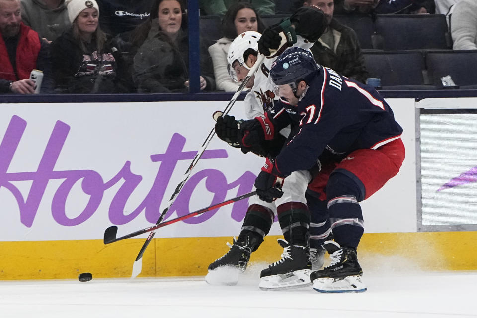 Arizona Coyotes' Nick Schmaltz, left, and Columbus Blue Jackets' Justin Danforth vie for control of the puck during the first period of an NHL hockey game Thursday, Nov. 16, 2023, in Columbus, Ohio. (AP Photo/Sue Ogrocki)