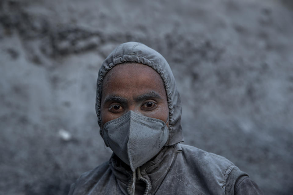 Mohammad Saleem, a drilling machine operator is covered with dust as he poses for picture at the entrance of Nilgrar Tunnel in Baltal area, northeast of Srinagar, Indian controlled Kashmir, Tuesday, Sept. 28, 2021. High in a rocky Himalayan mountain range, hundreds of people are working on an ambitious project to drill tunnels and construct bridges to connect the Kashmir Valley with Ladakh, a cold-desert region isolated half the year because of massive snowfall. The $932 million project’s last tunnel, about 14 kilometers (9 miles) long, will bypass the challenging Zojila pass and connect Sonamarg with Ladakh. Officials say it will be India’s longest and highest tunnel at 11,500 feet (3,485 meters). (AP Photo/Dar Yasin)