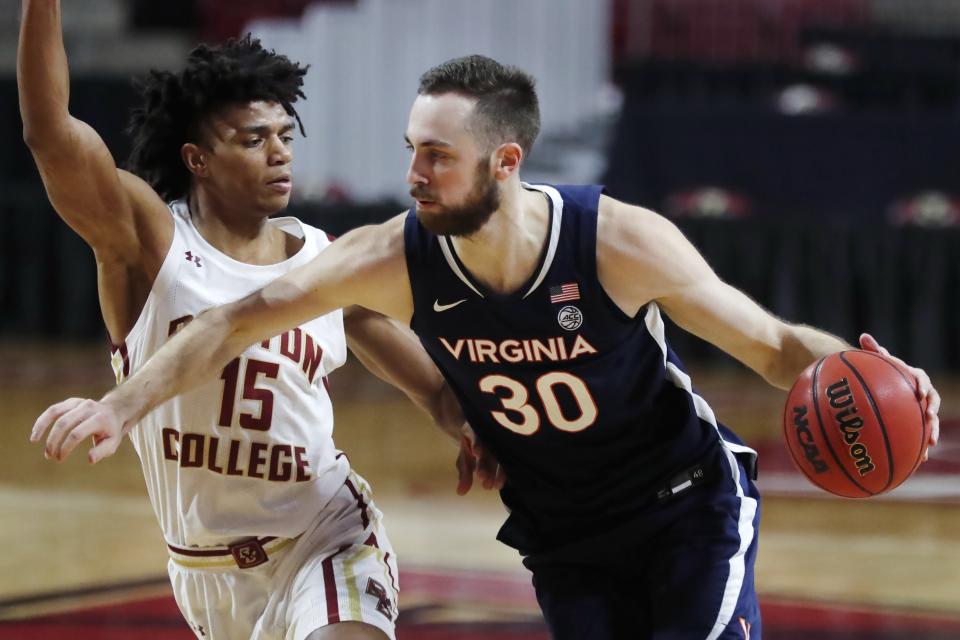 Virginia's Jay Huff (30) drives past Boston College's Demarr Langford Jr. (15) during the first half of an NCAA college basketball game, Saturday, Jan. 9, 2021, in Boston. (AP Photo/Michael Dwyer)