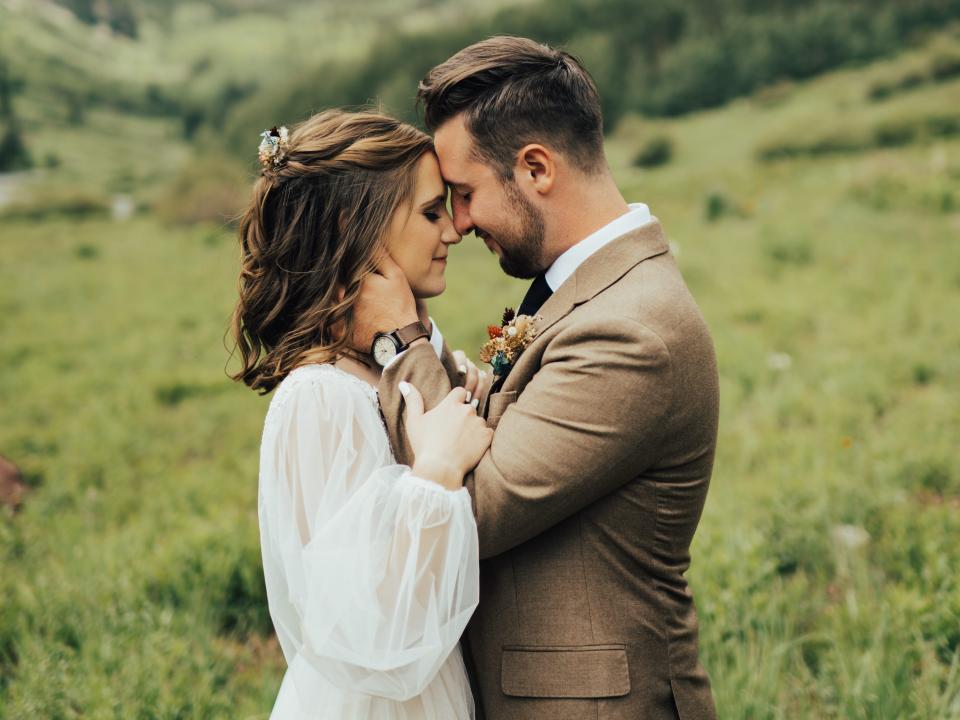 abi and her husband posing for a photo in maroon bells amphitheater on their wedding day