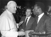 FILE - In this March 18, 1987 file photo, Pope John Paul II shakes hands with Brazil's former soccer player Pele during a private audience at the Vatican. On Oct. 23, 2020, the three-time World Cup winner Pelé turns 80 without a proper celebration amid the COVID-19 pandemic as he quarantines in his mansion in the beachfront city of Guarujá, where he has lived since the start of the pandemic. (AP Photo/Arturo Mari, File)