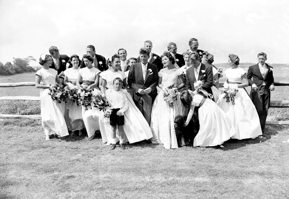 John F. Kennedy, in his first year in the U.S. Senate, and the former Jacqueline Lee Bouvier, described as a 'socialite career girl,' are flanked by their twenty attendants, page boy, and flower girl on their wedding day. (Photo by Pat Candido/NY Daily News Archive via Getty Images)