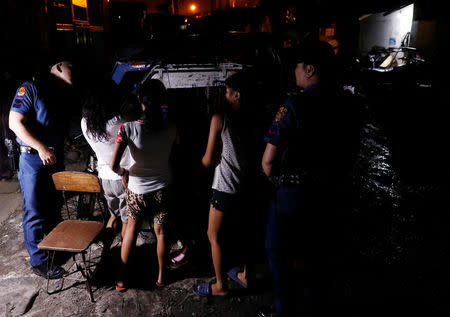 Police officers interrogate teenagers after they are rounded up lingering in the streets of Tondo, Manila, Philippines July 2, 2018. REUTERS/Erik De Castro/Files