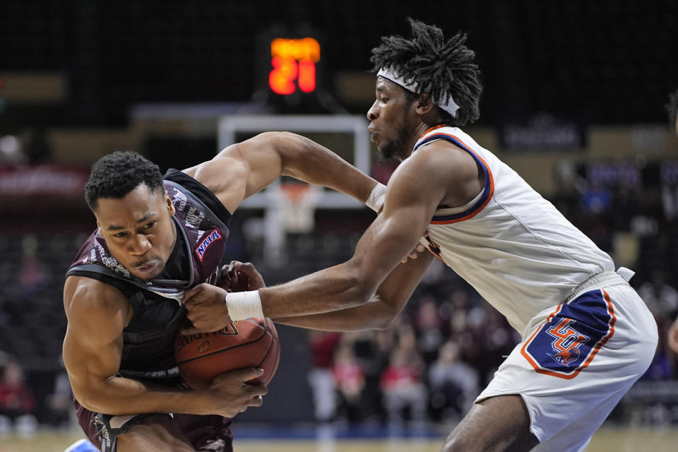 Langston guard Toru Dean, right, tries to steal the ball from Freed-Hardeman guard JJ Wheat, right, during the first half of the NAIA men's national championship college basketball game, Tuesday, March 26, 2024, in Kansas City, Mo. (AP Photo/Charlie Riedel)