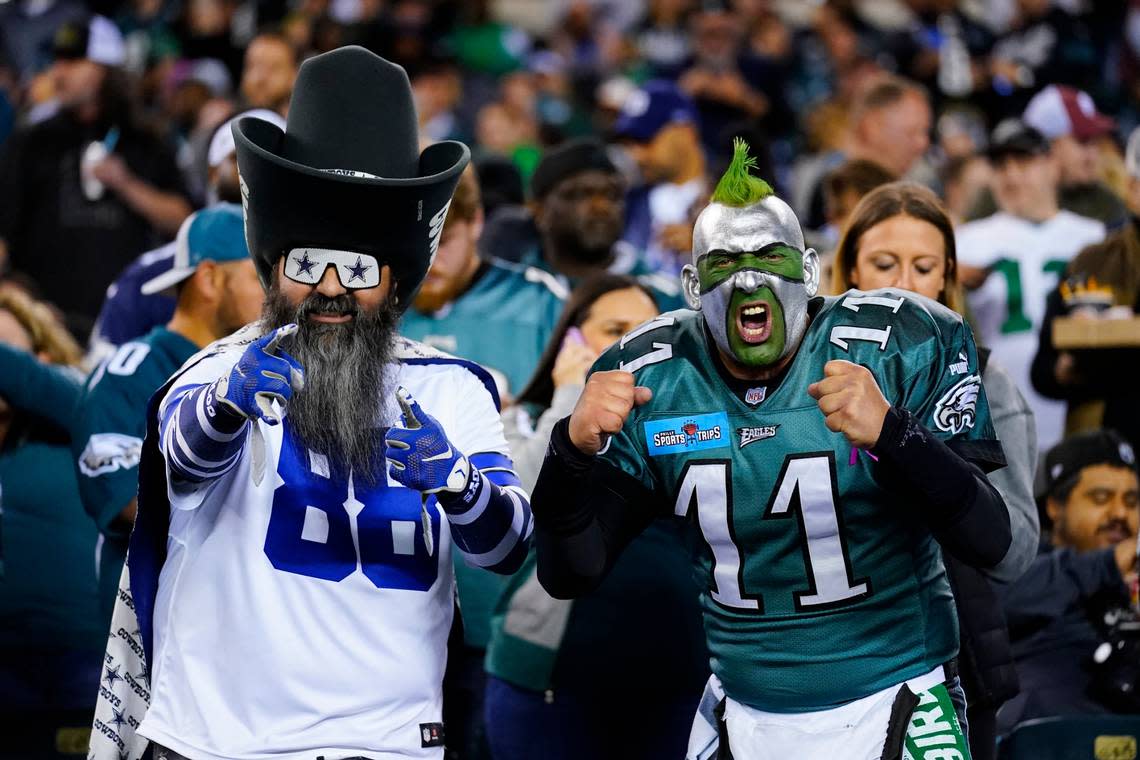 A Dallas Cowboys fan and Philadelphia Eagles fan pose before an NFL football game between the Eagles and Cowboys on Sunday, Oct. 16, 2022, in Philadelphia.