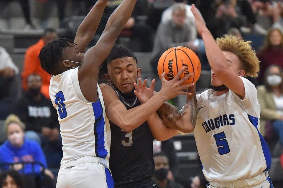 Wakefield’s Jamal Norris (5) drives to the basket between Wake Forest’s Jaden Valentine (0) and A.J. Smalls (5) during the first half. The Wakefield Wolverines and the Wake Forest Cougars met in a conference basketball game in Wake Forest, NC on January 14, 2022.