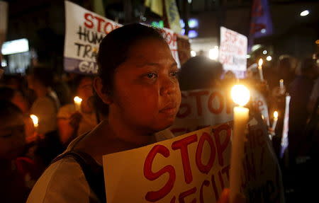 Activists display placards as they hold a candlelight vigil for death row prisoner Mary Jane Veloso outside Indonesian embassy in Makati, Philippines April 28, 2015. REUTERS/Erik De Castro